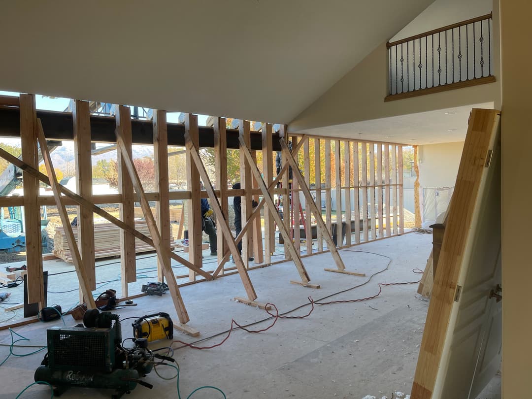 Interior of a home under renovation, showcasing wooden framing and construction tools visible.