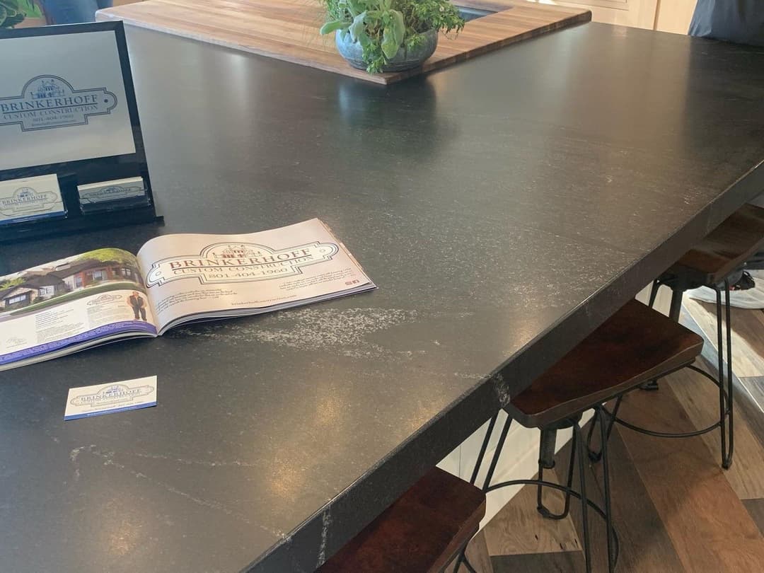 Modern black countertop with a brochure for Brinkerhoff Construction and potted plant.