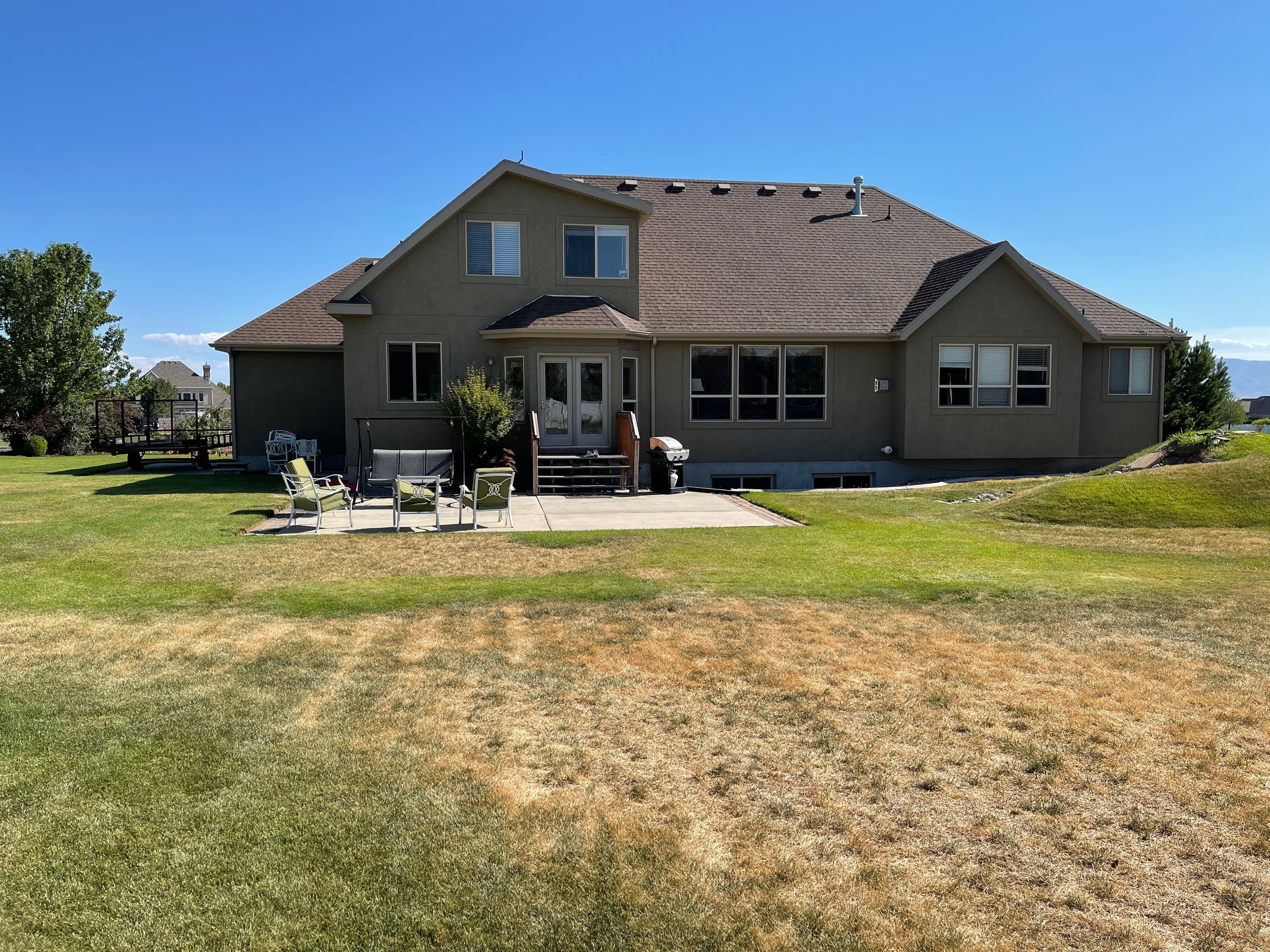 Large suburban home with a spacious backyard and patio, perfect for outdoor relaxation.