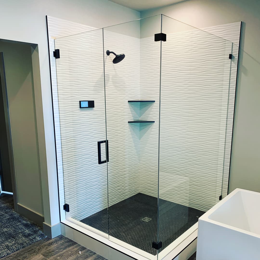Modern glass shower enclosure with textured wall tiles and minimalist design elements.