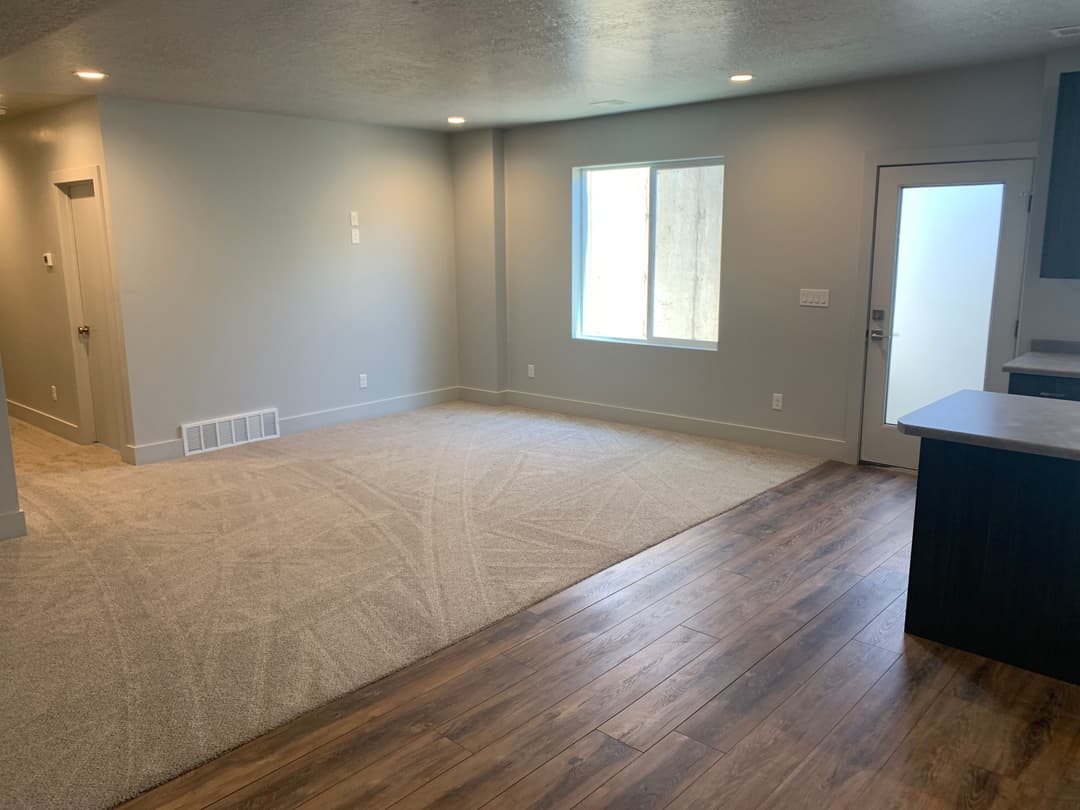 Modern living room with carpet flooring, natural light, and neutral wall colors.