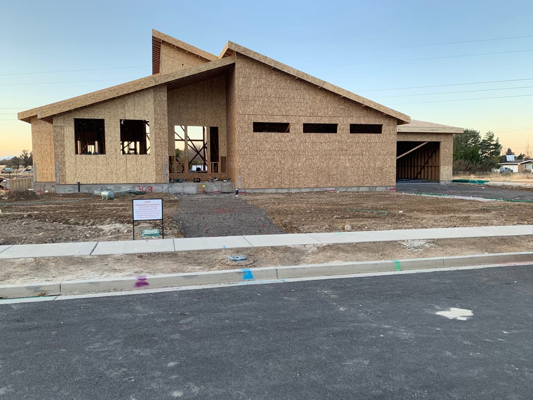 Newly built residential home under construction with wood framing and foundation visible.