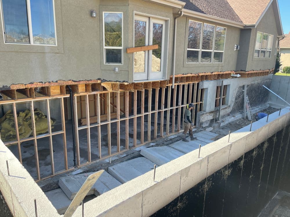 Home under construction with exposed framing and foundation work in progress.
